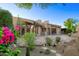 Backyard patio area featuring colorful flowers, desert landscaping, and rock features at 1637 N Quartz Valley Rd, Scottsdale, AZ 85266