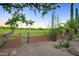 Backyard with mature tree, desert landscaping, and gate to the golf course at 1637 N Quartz Valley Rd, Scottsdale, AZ 85266