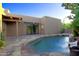 The backyard boasts a refreshing pool, a tranquil waterfall feature, and desert landscaping at 1637 N Quartz Valley Rd, Scottsdale, AZ 85266