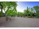 Paver driveway leading to a landscaped yard with mature trees and desert foliage at 1637 N Quartz Valley Rd, Scottsdale, AZ 85266