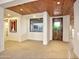 Hallway with wooden ceiling leading to a custom door and views of desert landscaping at 1637 N Quartz Valley Rd, Scottsdale, AZ 85266