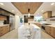 Bright kitchen with an island with marble countertop, custom wooden cabinets and modern appliances at 1637 N Quartz Valley Rd, Scottsdale, AZ 85266