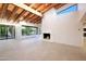 Bright living room with wood beam ceiling, a modern fireplace, and floor-to-ceiling windows with desert views at 1637 N Quartz Valley Rd, Scottsdale, AZ 85266