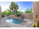 Inviting pool area with stone accents, mature desert landscaping, and a tranquil waterfall feature at 1637 N Quartz Valley Rd, Scottsdale, AZ 85266