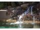 Water tumbles down a stone waterfall feature into the sparkling pool at 1637 N Quartz Valley Rd, Scottsdale, AZ 85266