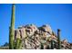 Desert rock formation under a bright sky, framed by Saguaro cacti at 1637 N Quartz Valley Rd, Scottsdale, AZ 85266