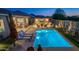 Inviting backyard with a sparkling pool, comfortable lounge chairs, a covered patio, and cacti landscaping at 17018 W Saguaro Park Ln, Surprise, AZ 85387