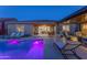 Beautiful backyard featuring a pool, covered patio, lounge chairs and access to the home's interior at 17018 W Saguaro Park Ln, Surprise, AZ 85387