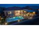 Aerial view of a backyard with a pool, covered seating area, a built-in grill, and lush landscaping, perfect for relaxation at 17018 W Saguaro Park Ln, Surprise, AZ 85387