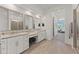 Modern bathroom with dual sinks, granite countertops, tile flooring, white cabinetry, and a glass-enclosed shower at 17018 W Saguaro Park Ln, Surprise, AZ 85387