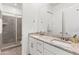 Bathroom featuring granite countertops, double sinks and glass-enclosed shower at 17018 W Saguaro Park Ln, Surprise, AZ 85387