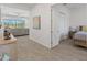 Light-filled entryway and hallway leading into an open-concept living room and bedroom at 17018 W Saguaro Park Ln, Surprise, AZ 85387