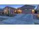 Beautiful desert home with multi-car garage, meticulous landscaping, and attractive curb appeal at dusk at 17018 W Saguaro Park Ln, Surprise, AZ 85387