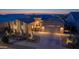 Charming desert home featuring meticulous landscaping, multi-car garage, and inviting curb appeal at dusk at 17018 W Saguaro Park Ln, Surprise, AZ 85387