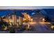 Beautiful home exterior at dusk, featuring a well-manicured desert landscape, a tile roof and a charming front gate at 17018 W Saguaro Park Ln, Surprise, AZ 85387