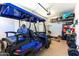 Organized garage featuring a blue golf cart and multiple shelves for storage at 17018 W Saguaro Park Ln, Surprise, AZ 85387