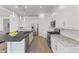 Bright, modern kitchen with white cabinets, stainless steel appliances, a large island, and a tile backsplash at 17018 W Saguaro Park Ln, Surprise, AZ 85387