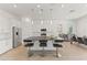 A modern kitchen features white cabinetry, a large kitchen island with chairs, stainless steel appliances, and tile flooring at 17018 W Saguaro Park Ln, Surprise, AZ 85387