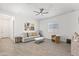 Modern living room with ceiling fan, tile flooring, and neutral decor at 17018 W Saguaro Park Ln, Surprise, AZ 85387