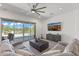Cozy living room featuring a comfortable gray sectional sofa, tile floors, a view of the backyard, and a large screen television at 17018 W Saguaro Park Ln, Surprise, AZ 85387