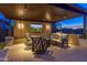 Inviting outdoor living space with a full kitchen, seating, television and views of the nearby mountains at 17018 W Saguaro Park Ln, Surprise, AZ 85387