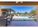 Expansive covered patio featuring views of the pool, outdoor kitchen, and desert landscaping at 17018 W Saguaro Park Ln, Surprise, AZ 85387