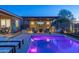Beautiful backyard pool area with an outdoor kitchen, seating and a sparkling pool with landscape lighting at 17018 W Saguaro Park Ln, Surprise, AZ 85387