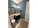 Bathroom with a wooden floor, blue walls, and a vanity with a dark cabinet and neutral countertop at 1718 S Longmore St # 53, Mesa, AZ 85202