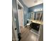 Bathroom with a wooden floor, blue walls, and a vanity with a dark cabinet and neutral countertop at 1718 S Longmore St # 53, Mesa, AZ 85202