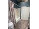 Bathroom with tub/shower, white tile, and blue walls with wood-look flooring and a sliding door closet at 1718 S Longmore St # 53, Mesa, AZ 85202