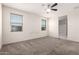 A spacious bedroom with a ceiling fan, two windows, and a view of the connected bathroom at 1748 W Cameron Blvd, Coolidge, AZ 85128
