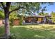 Large backyard with covered patio, mature trees, and well-maintained lawn perfect for recreation at 1825 E Palo Verde Dr, Phoenix, AZ 85016