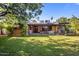 Expansive backyard featuring a well-kept lawn, charming patio, and mature landscaping for outdoor enjoyment at 1825 E Palo Verde Dr, Phoenix, AZ 85016