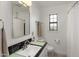 Bright bathroom with black and green tile accents, pedestal sink, and classic black and white flooring at 1825 E Palo Verde Dr, Phoenix, AZ 85016
