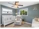 Cozy Bedroom featuring a white crib, soft-hued walls, and an inviting rocker near natural light at 1825 E Palo Verde Dr, Phoenix, AZ 85016