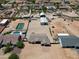 Aerial view highlighting the property's layout, tennis court, pool, and outbuildings at 19711 W Colter St, Litchfield Park, AZ 85340