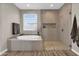 This bright bathroom features a soaking tub and a glass enclosed shower with stone floor at 19711 W Colter St, Litchfield Park, AZ 85340