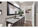 Bathroom featuring a granite countertop, dark cabinets, contemporary mirror, and wood flooring at 19711 W Colter St, Litchfield Park, AZ 85340