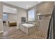 This bright bathroom has a soaking tub, glass shower, and wood look flooring with access to the bedroom at 19711 W Colter St, Litchfield Park, AZ 85340