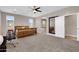 Large bedroom with neutral walls, carpet, ceiling fan, a doorway, and an ensuite bathroom at 19711 W Colter St, Litchfield Park, AZ 85340