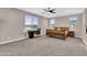 Spacious bedroom with a ceiling fan, carpet, and a work space near a window with natural light at 19711 W Colter St, Litchfield Park, AZ 85340