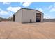 Wide property showcasing a large metal building with equipment and a hose, secured by fencing and a gravel area at 19711 W Colter St, Litchfield Park, AZ 85340