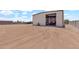 Spacious property showcasing a large metal building with equipment and a tractor, secured by fencing and a gravel area at 19711 W Colter St, Litchfield Park, AZ 85340