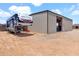 Wide property showcasing a large metal building with an RV, secured by fencing and a gravel area at 19711 W Colter St, Litchfield Park, AZ 85340