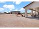 Expansive gravel area with a covered patio, dining set, and a large metal building offering versatile possibilities at 19711 W Colter St, Litchfield Park, AZ 85340