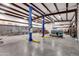 Inside the garage featuring a vehicle lift, boat, tractor, and various tools in a well-lit and organized space at 19711 W Colter St, Litchfield Park, AZ 85340