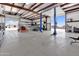 Bright garage with a car lift, tools, and large garage door leading to the backyard at 19711 W Colter St, Litchfield Park, AZ 85340