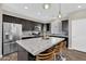 Modern kitchen with dark cabinets, stainless steel appliances, granite countertops, and stylish pendant lighting at 19711 W Colter St, Litchfield Park, AZ 85340