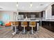 Modern kitchen featuring an eat-in island with pendant lighting, dark cabinets, and stainless steel appliances at 19711 W Colter St, Litchfield Park, AZ 85340