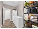 Functional laundry room with a full-size washer and dryer and ample storage shelving at 19711 W Colter St, Litchfield Park, AZ 85340